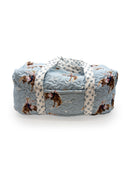 Quilted duffle with patterned strap on a white background