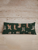Long rectangular pillow with cowboy boot pattern on a wooden surface